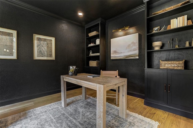 office area featuring baseboards, built in shelves, light wood-type flooring, and crown molding