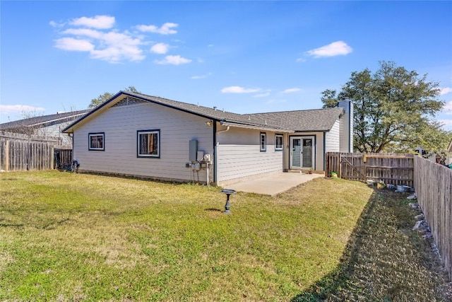 back of property featuring a fenced backyard, a yard, a chimney, and a patio