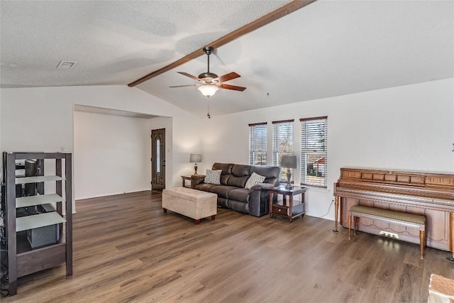 living room with lofted ceiling with beams, ceiling fan, a textured ceiling, and wood finished floors