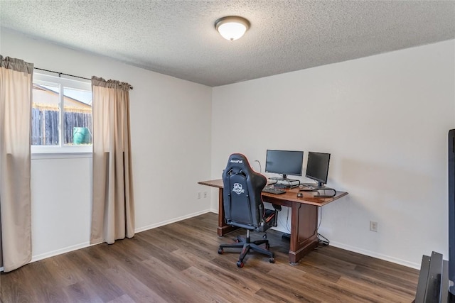 home office featuring a textured ceiling, baseboards, and wood finished floors