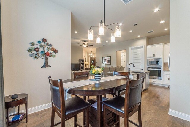 409 Flying Orchid Dr, San Marcos, TX 78666 - dining space featuring dark wood-style flooring, recessed lighting, ceiling fan, and a chandelier