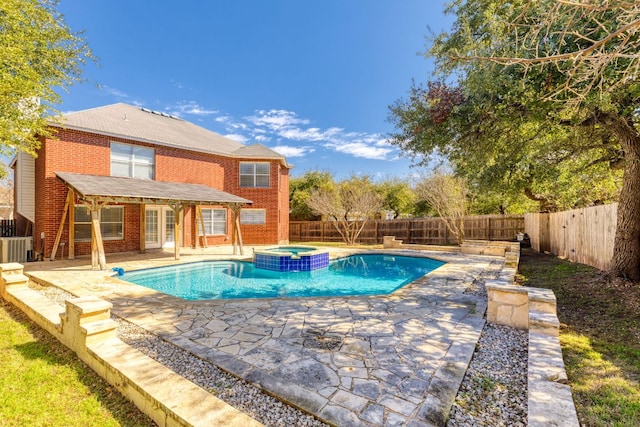 view of pool featuring a pool with connected hot tub, a fenced backyard, and a patio