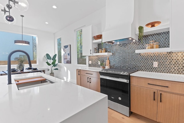 4402 Garnett St Unit 1, Austin, TX 78745 - kitchen with open shelves, stainless steel stove, custom exhaust hood, light countertops, and recessed lighting