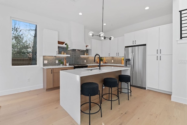 4402 Garnett St Unit 1, Austin, TX 78745 - kitchen featuring stainless steel fridge with ice dispenser, a sink, open shelves, light countertops, and decorative backsplash