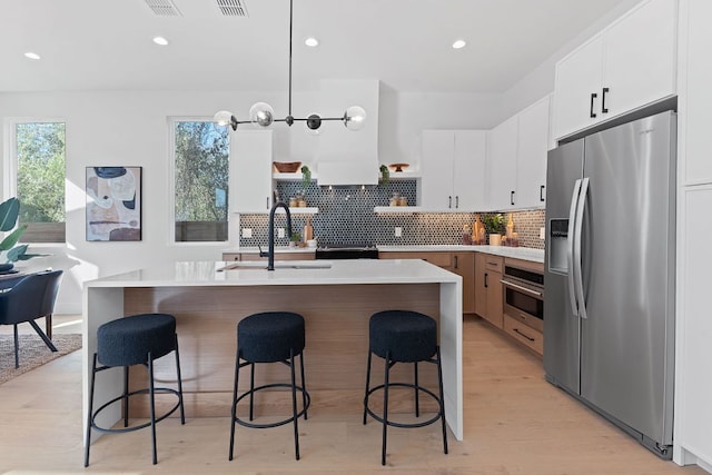 4402 Garnett St Unit 1, Austin, TX 78745 - kitchen with appliances with stainless steel finishes, a sink, open shelves, light countertops, and backsplash