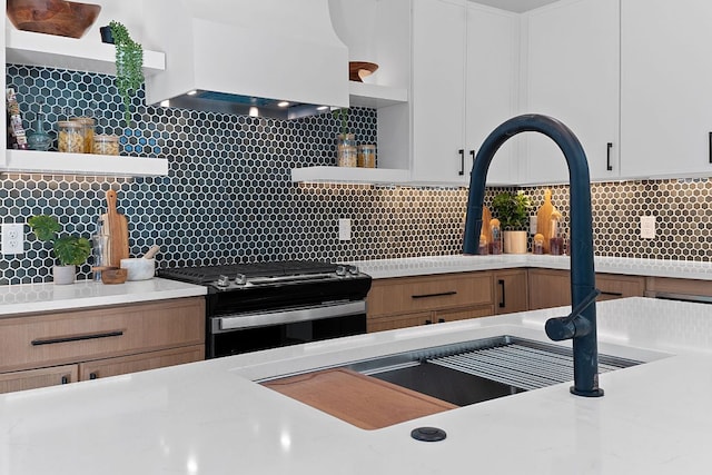 4402 Garnett St Unit 1, Austin, TX 78745 - kitchen with open shelves, range, custom range hood, and decorative backsplash