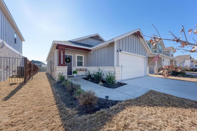 view of front of home featuring board and batten siding, concrete driveway, fence, and an attached garage