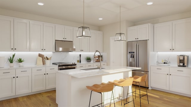 kitchen with a kitchen island with sink, under cabinet range hood, stainless steel appliances, white cabinets, and light wood-type flooring