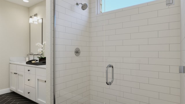 bathroom featuring baseboards, a shower stall, and vanity