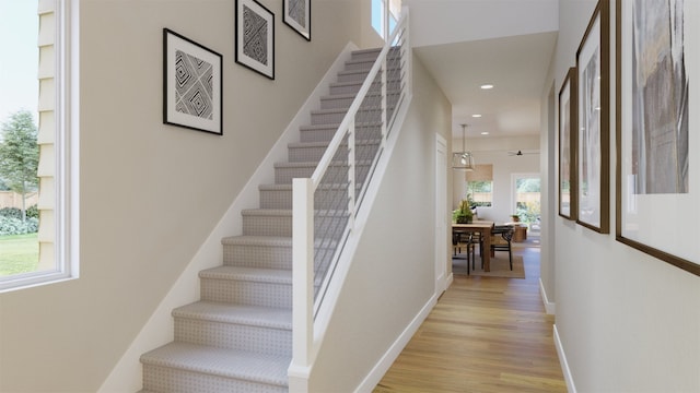 staircase with recessed lighting, baseboards, and wood finished floors