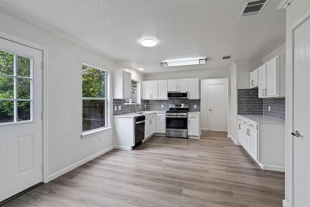 kitchen with light countertops, visible vents, appliances with stainless steel finishes, light wood-style floors, and a sink