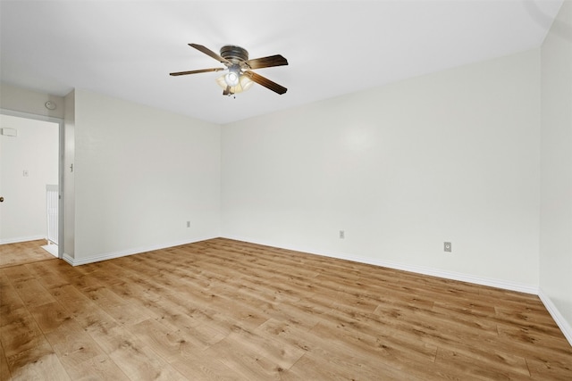 empty room featuring baseboards, a ceiling fan, and light wood-style floors