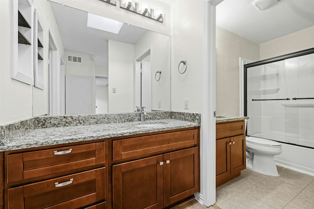 full bathroom with tile patterned flooring, toilet, a skylight, vanity, and visible vents