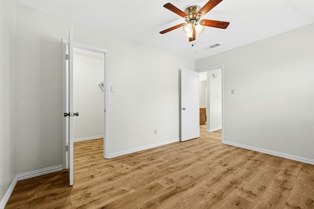 unfurnished bedroom with baseboards, a ceiling fan, visible vents, and light wood-style floors