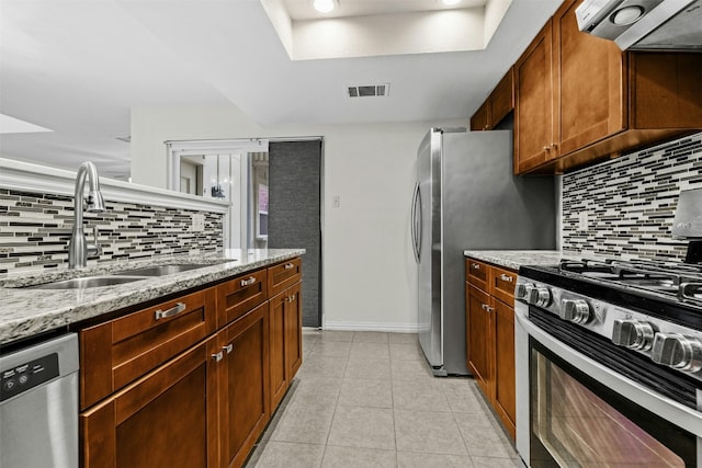 kitchen featuring stainless steel appliances, visible vents, light tile patterned flooring, a sink, and exhaust hood