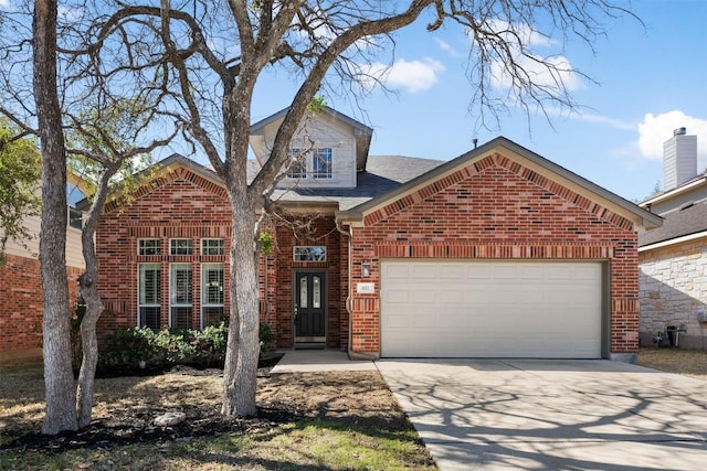 traditional home with a garage, concrete driveway, brick siding, and roof with shingles