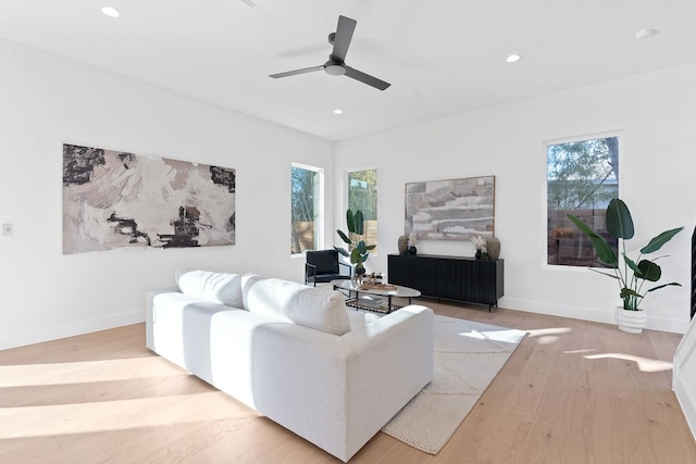 living area featuring a wealth of natural light, baseboards, wood finished floors, and recessed lighting