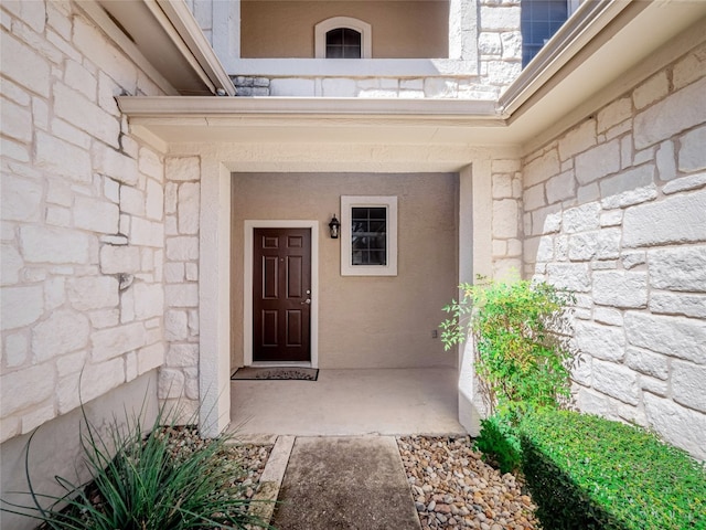 entrance to property with a balcony and stone siding