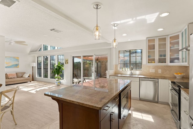 kitchen featuring stainless steel appliances, open floor plan, a healthy amount of sunlight, and a sink