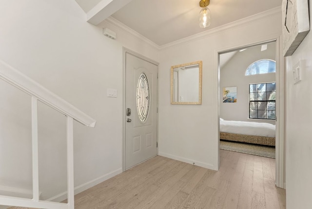 entryway with ornamental molding, wood finished floors, and baseboards