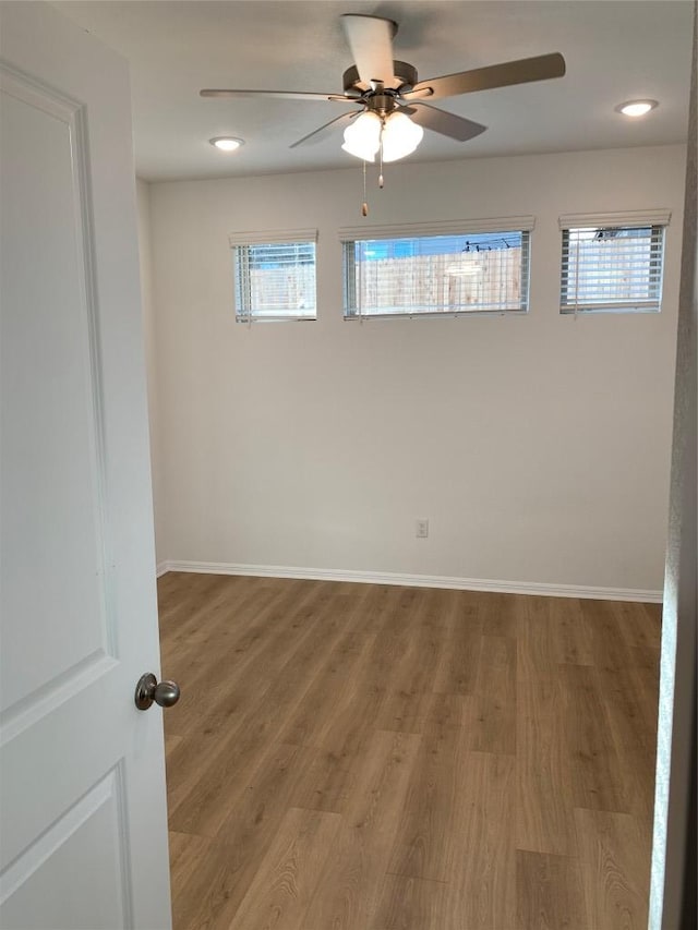 unfurnished room featuring ceiling fan, recessed lighting, wood finished floors, and baseboards