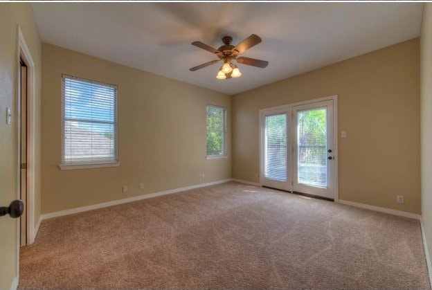 empty room featuring light carpet, ceiling fan, and baseboards