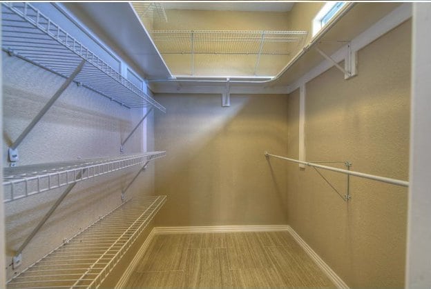 walk in closet with wood finished floors