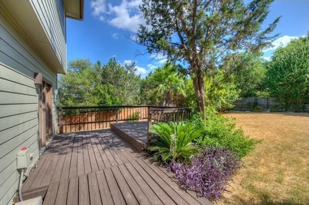 wooden deck featuring a yard and fence