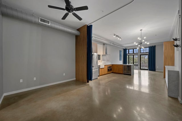 2235 E 6th St Unit 210, Austin, TX 78702 - kitchen with wall chimney range hood, concrete floors, a peninsula, open floor plan, and baseboards