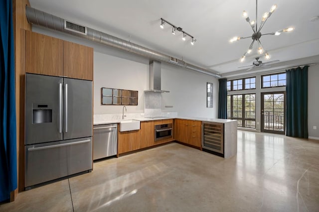 2235 E 6th St Unit 210, Austin, TX 78702 - kitchen featuring stainless steel appliances, wine cooler, wall chimney exhaust hood, and brown cabinetry