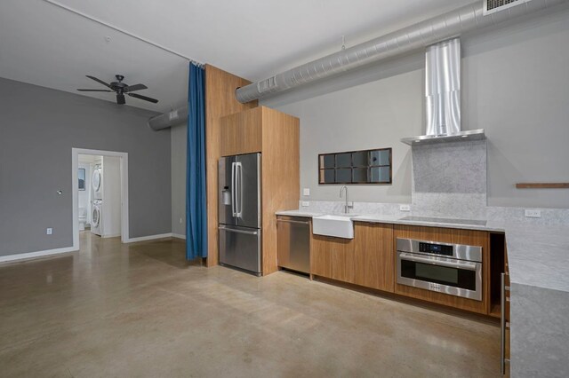 2235 E 6th St Unit 210, Austin, TX 78702 - kitchen featuring stainless steel appliances, a sink, brown cabinets, finished concrete floors, and modern cabinets