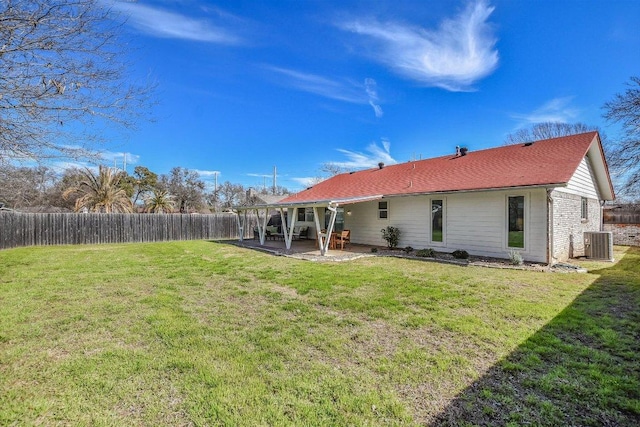 rear view of house with central AC, a yard, a patio, and a fenced backyard