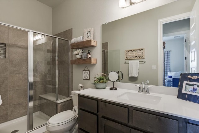 full bathroom featuring vanity, a stall shower, and toilet