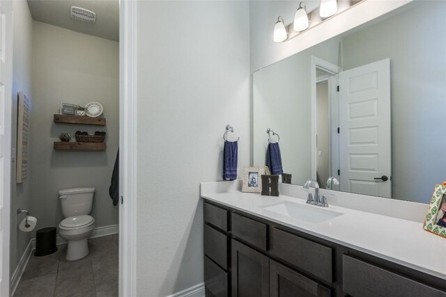 bathroom with tile patterned flooring, vanity, toilet, baseboards, and visible vents