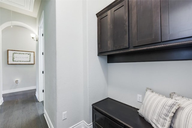 mudroom featuring dark wood-type flooring, attic access, and baseboards