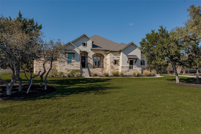 view of front facade with a front yard and stone siding