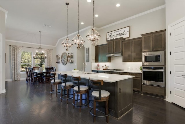 kitchen with crown molding, appliances with stainless steel finishes, a sink, and light countertops