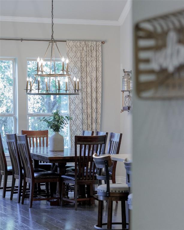 dining area featuring crown molding, a notable chandelier, and wood finished floors