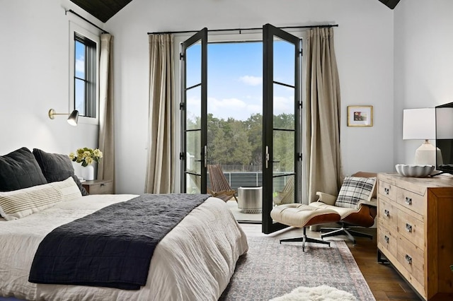 bedroom featuring access to outside, vaulted ceiling, and dark wood-type flooring