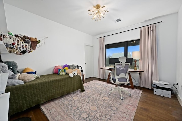 bedroom with visible vents and wood finished floors