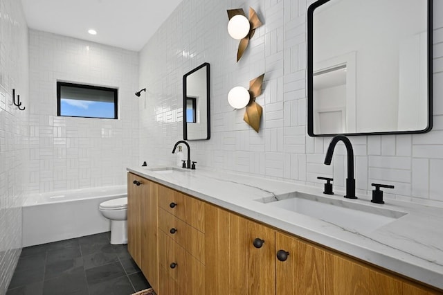 full bath featuring toilet, double vanity, bathtub / shower combination, and a sink