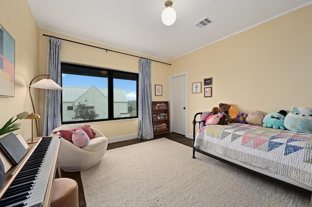 bedroom featuring wood finished floors, visible vents, and baseboards