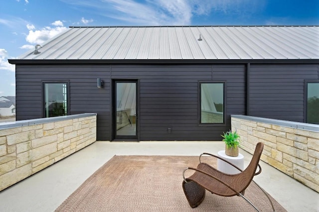 back of house featuring metal roof, a patio, and a standing seam roof