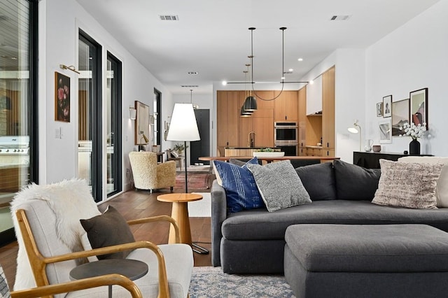 living area with visible vents, wood finished floors, and recessed lighting