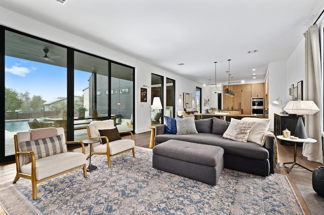 living area featuring visible vents and wood finished floors