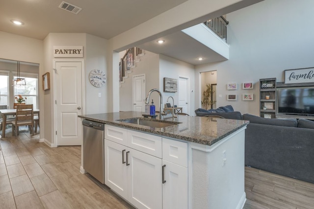 116 Evening Star Ln, Georgetown, TX 78628 - kitchen with stainless steel dishwasher, a sink, dark stone counters, white cabinetry, and open floor plan