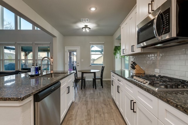 116 Evening Star Ln, Georgetown, TX 78628 - kitchen with appliances with stainless steel finishes, a sink, baseboards, decorative backsplash, and white cabinets