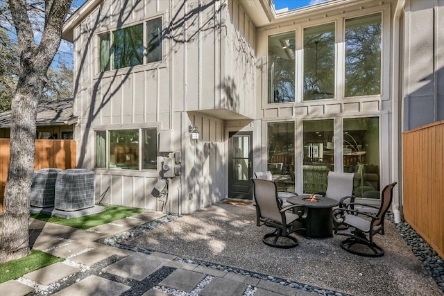 back of house with a fire pit, a patio, central AC unit, and fence