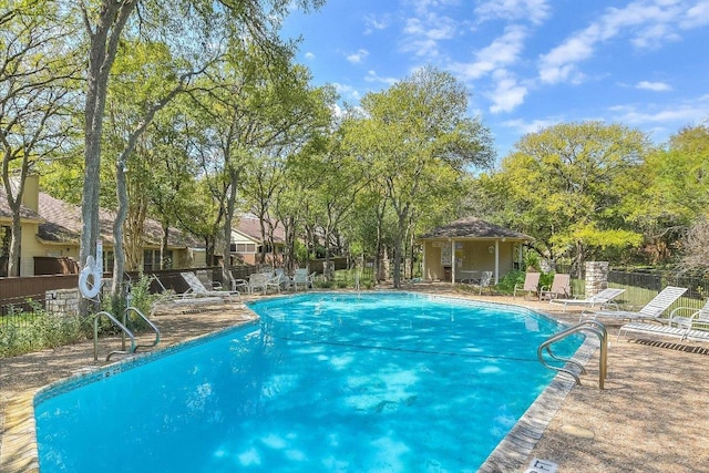 pool with a patio area and fence