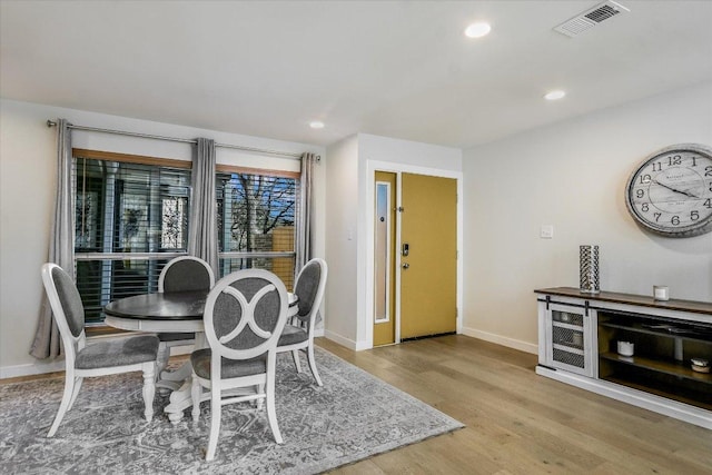 dining space featuring baseboards, visible vents, wood finished floors, and recessed lighting